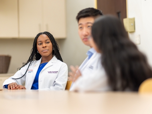 A group of medical students sitting around a table and talking