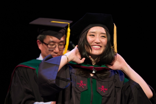 A graduate receives her doctoral hood at convocation